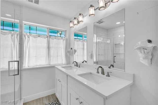 bathroom featuring wood-type flooring, vanity, and a shower with door