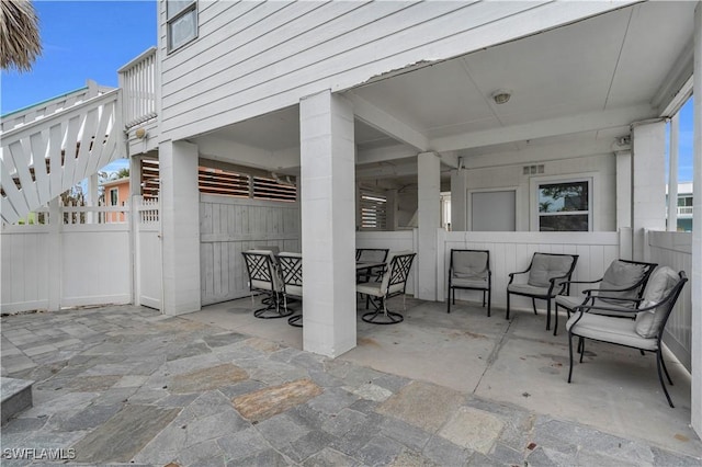 view of patio / terrace with outdoor dining space, fence, and stairs