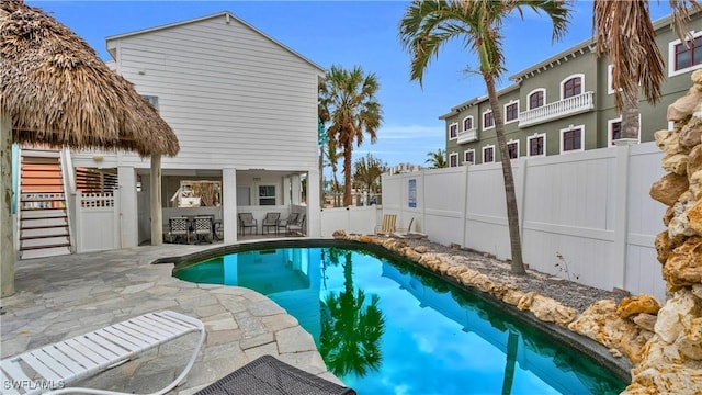 view of swimming pool featuring a patio area, a fenced backyard, outdoor dry bar, and a fenced in pool