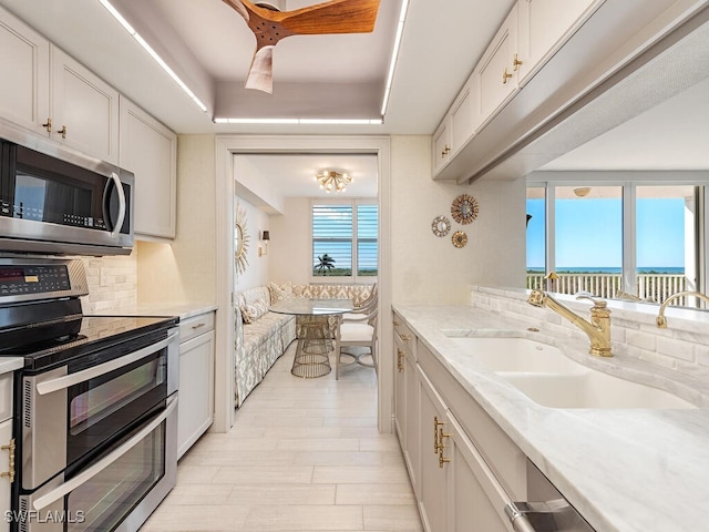 kitchen with white cabinetry, plenty of natural light, stainless steel appliances, and sink