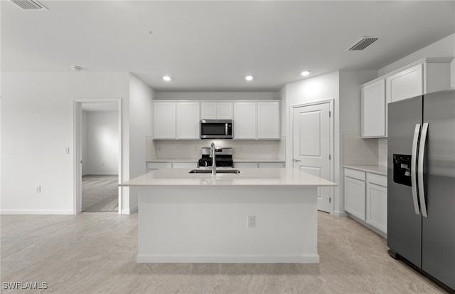 kitchen with white cabinetry, a kitchen island with sink, appliances with stainless steel finishes, and tasteful backsplash