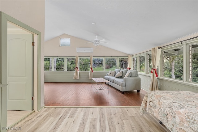 unfurnished bedroom with ceiling fan, light hardwood / wood-style floors, lofted ceiling, and a wall unit AC