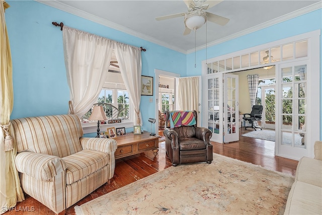 living area featuring french doors, ornamental molding, dark wood-type flooring, and ceiling fan