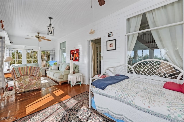 bedroom with wooden walls and wood-type flooring