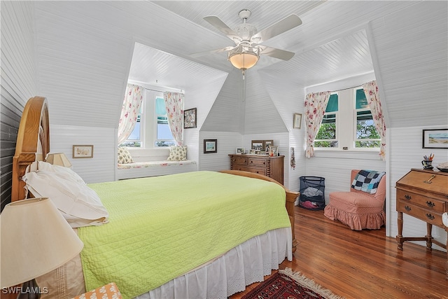 bedroom with ceiling fan, vaulted ceiling, wood-type flooring, and multiple windows