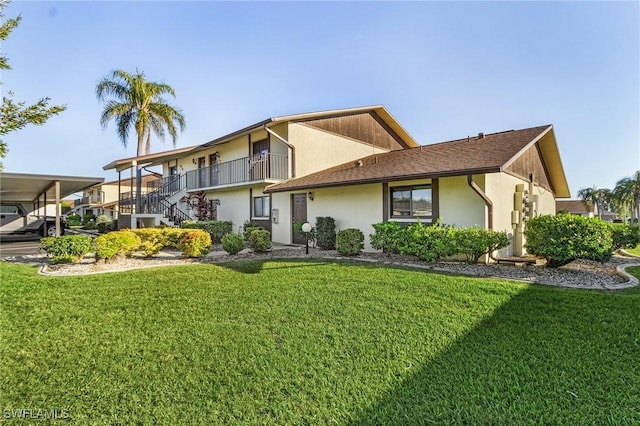 view of front of house with a front lawn and a carport