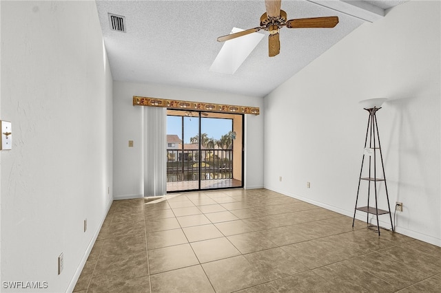 unfurnished room with tile patterned floors, a textured ceiling, lofted ceiling with skylight, and ceiling fan