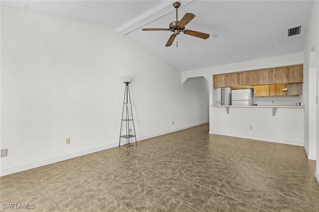 unfurnished living room with vaulted ceiling with beams, ceiling fan, and a textured ceiling