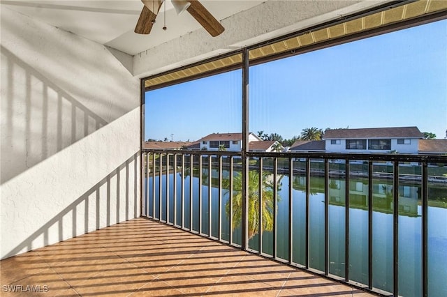 balcony with ceiling fan and a water view