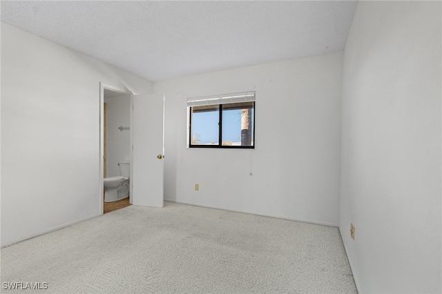 carpeted empty room featuring a textured ceiling