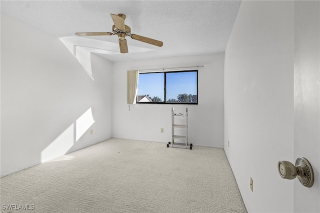 carpeted spare room with ceiling fan and a textured ceiling