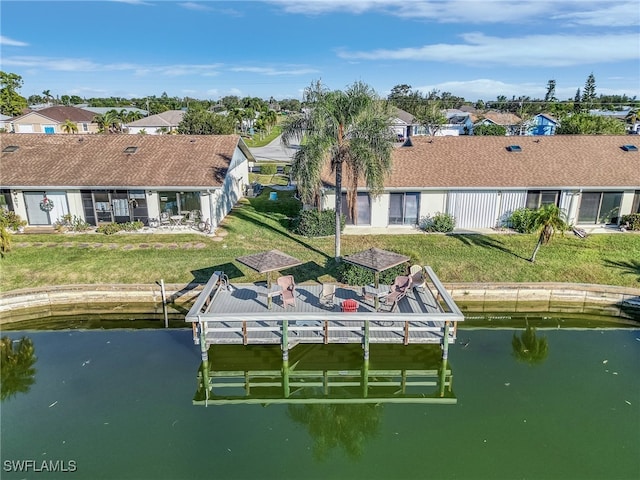 dock area with a lawn and a water view