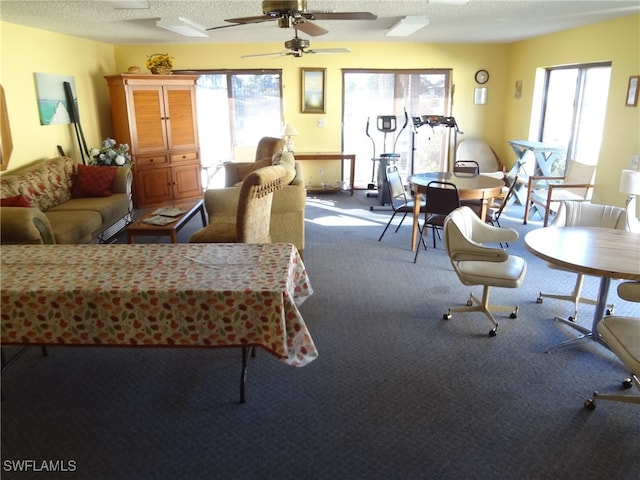 carpeted living room featuring a textured ceiling, a wealth of natural light, and ceiling fan