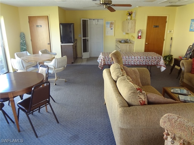 carpeted living room featuring ceiling fan