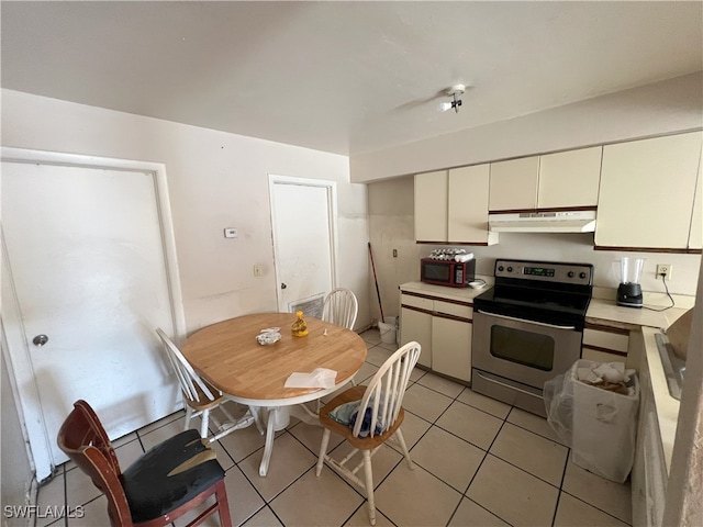 kitchen featuring stainless steel range with electric stovetop and light tile patterned flooring