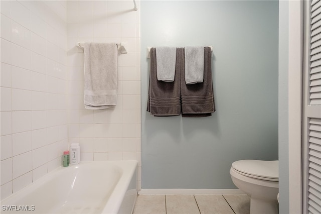 bathroom featuring tile patterned flooring, a bathtub, and toilet