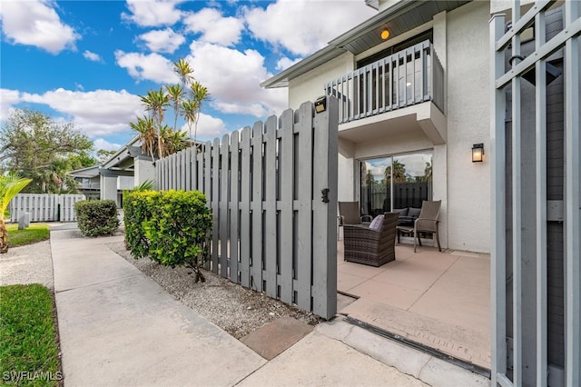 view of side of home featuring a patio area, outdoor lounge area, and a balcony