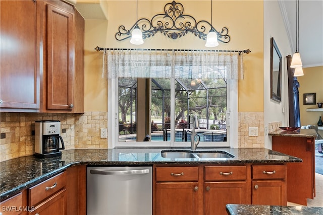 kitchen featuring dark stone countertops, pendant lighting, stainless steel dishwasher, and sink