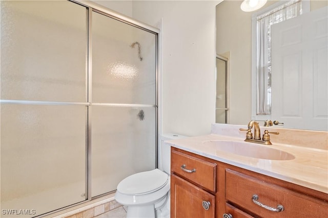 bathroom with vanity, toilet, and a shower with shower door