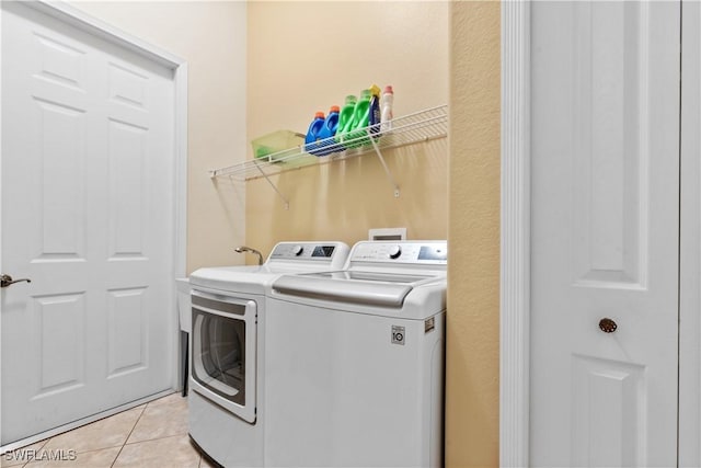 washroom featuring washing machine and dryer and light tile patterned flooring