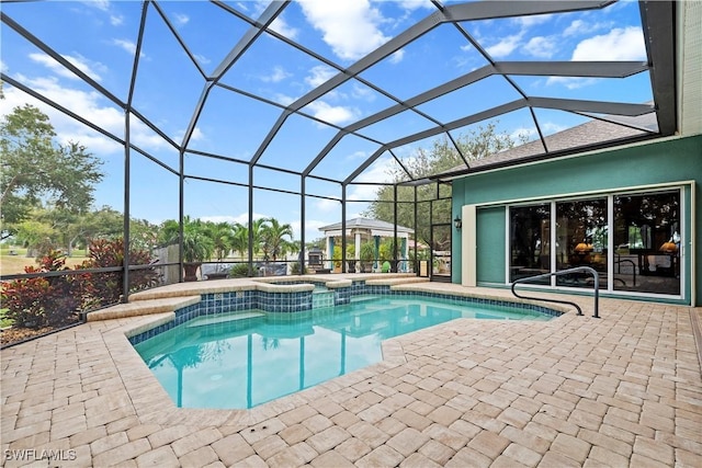 view of swimming pool with glass enclosure, a patio area, and an in ground hot tub