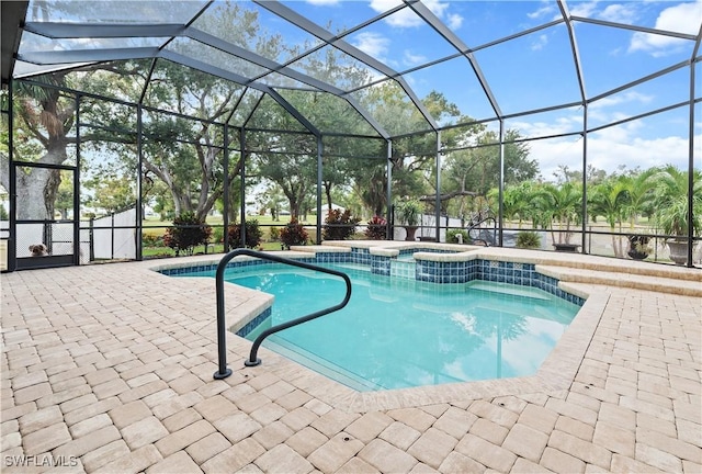 view of swimming pool featuring a patio area, a lanai, and an in ground hot tub