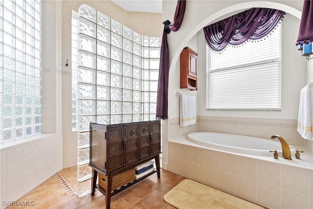 bathroom featuring tile patterned flooring, a bath, and walk in shower