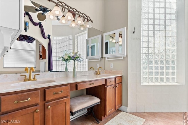 bathroom featuring ceiling fan, double vanity, a sink, and tile patterned floors