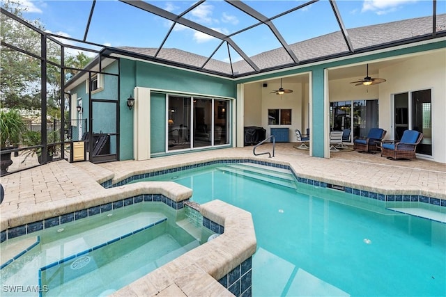 view of pool with a patio, glass enclosure, a pool with connected hot tub, and a ceiling fan