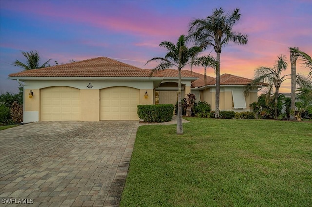 mediterranean / spanish house with a garage and a lawn