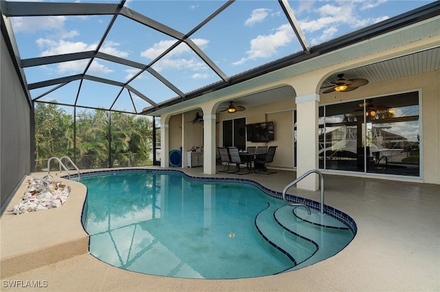 view of swimming pool featuring ceiling fan, glass enclosure, and a patio