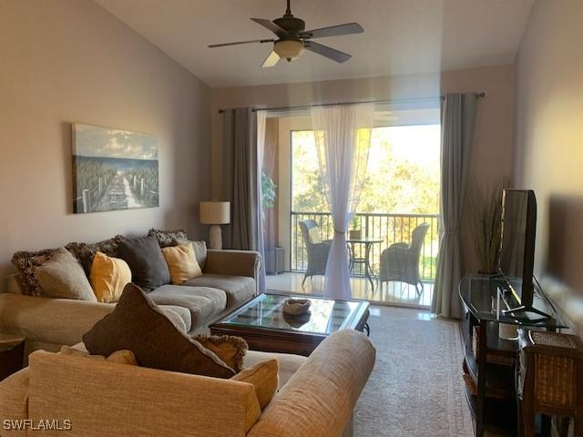 living room with lofted ceiling, carpet, and ceiling fan