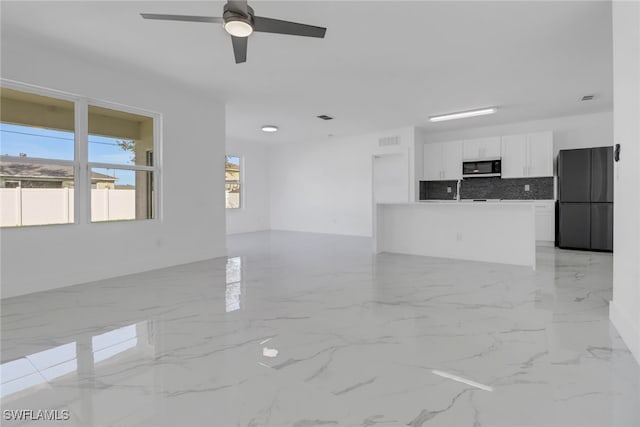 unfurnished living room featuring ceiling fan and sink