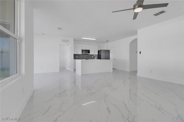 unfurnished living room with ceiling fan