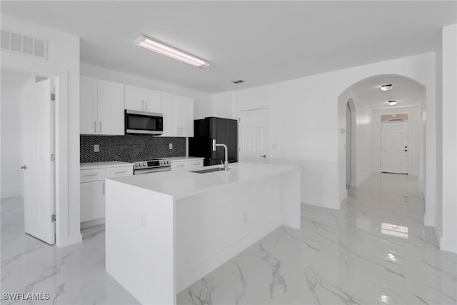 kitchen featuring white cabinetry, appliances with stainless steel finishes, a center island with sink, and sink