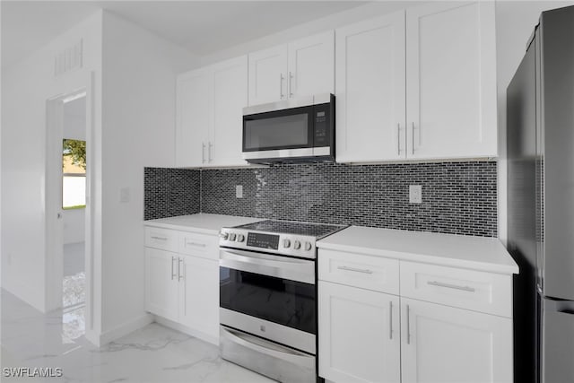 kitchen featuring stainless steel appliances, white cabinets, and tasteful backsplash