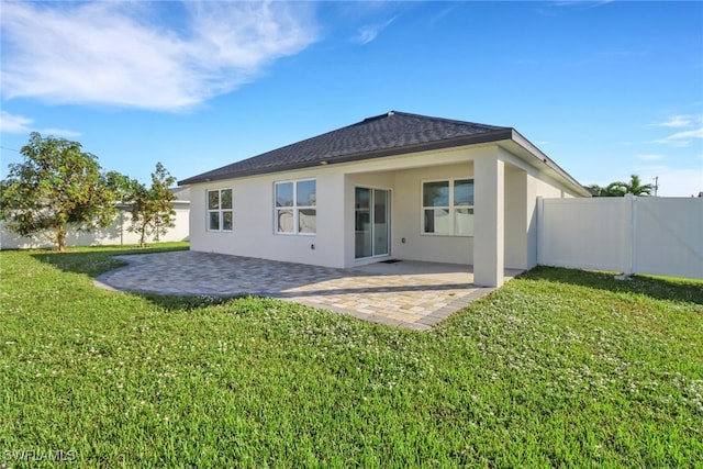 back of property with a patio and a yard