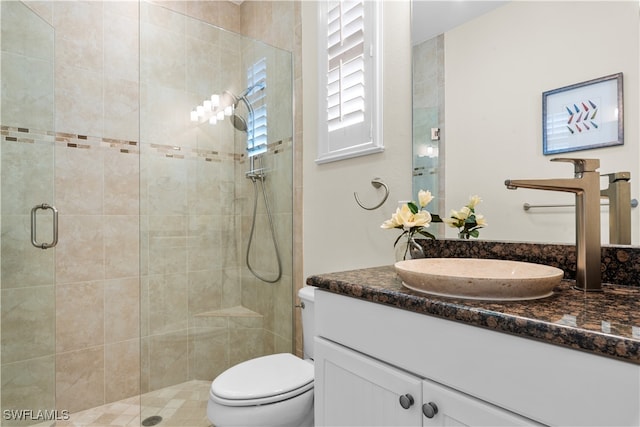 bathroom featuring walk in shower, vanity, and toilet