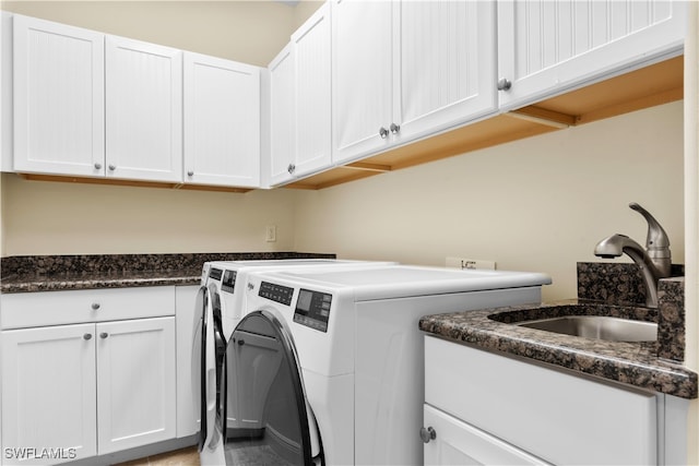 washroom featuring sink, cabinets, and independent washer and dryer