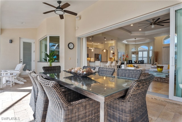 dining space with ornamental molding, a raised ceiling, and ceiling fan