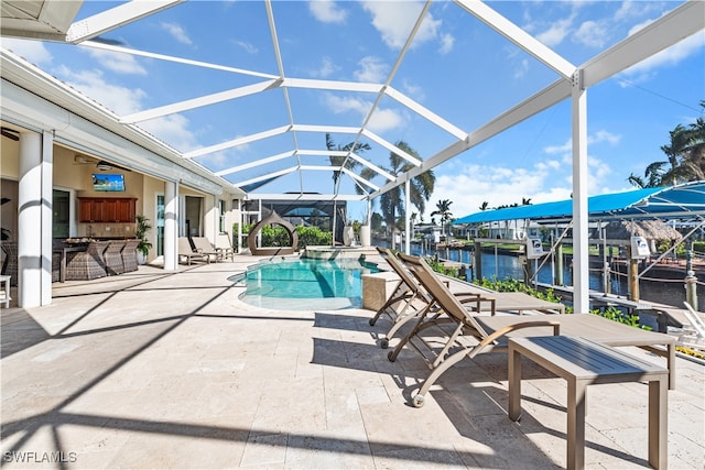 view of swimming pool with a patio, a water view, a bar, ceiling fan, and glass enclosure