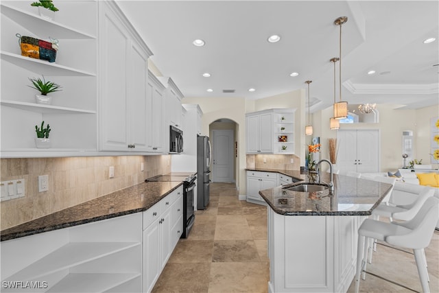 kitchen with sink, stainless steel appliances, decorative light fixtures, and white cabinetry