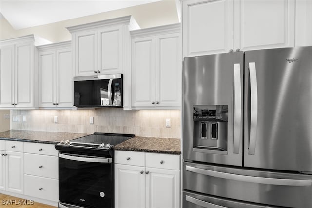 kitchen with stainless steel appliances, dark stone countertops, decorative backsplash, and white cabinetry