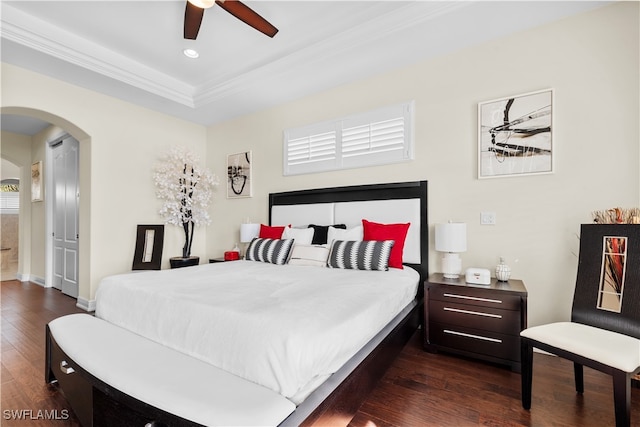 bedroom with ceiling fan, dark hardwood / wood-style flooring, ornamental molding, and a raised ceiling