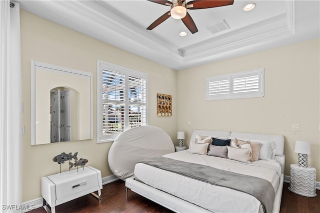 bedroom featuring ceiling fan, dark hardwood / wood-style flooring, a raised ceiling, and crown molding