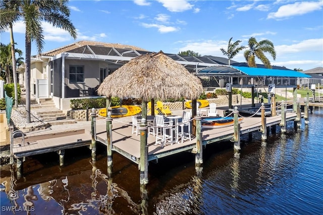 dock area featuring a water view, a gazebo, and glass enclosure