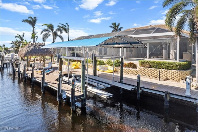 dock area with a lanai and a water view