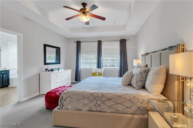 carpeted bedroom featuring ceiling fan, a tray ceiling, and connected bathroom