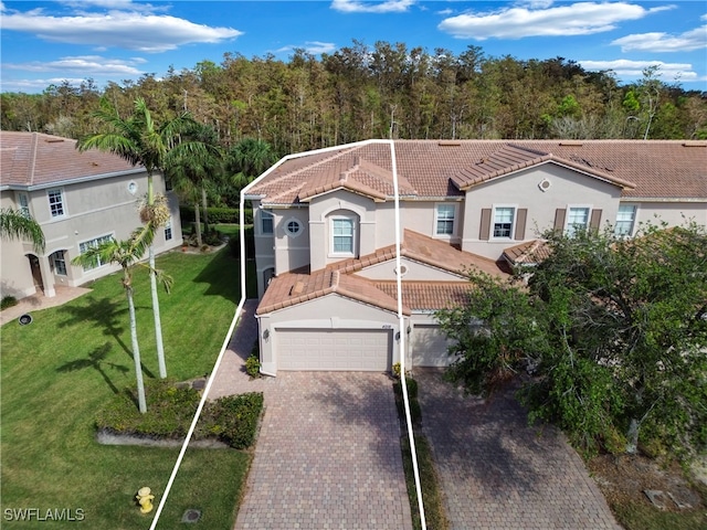 mediterranean / spanish-style home with a front lawn and a garage