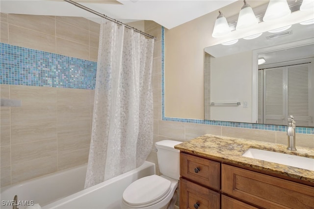 full bathroom with vanity, toilet, shower / bath combo with shower curtain, and tile walls